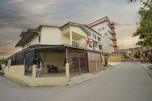 A two-story building with a covered porch and a gated entrance.