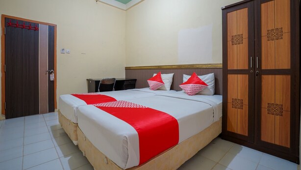 Un dormitorio con cama, armario y escritorio.