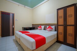 A bedroom with a bed, a wardrobe, and a desk.