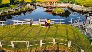 A park with a pond, wooden walkways, and a gazebo. - Charming Holiday Lodge (Hulhudhoo)