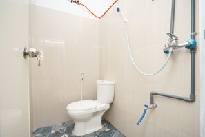 A bathroom with a toilet, a shower, and a sink. - OYO 2492 Nindy Homestay (Probolinggo)