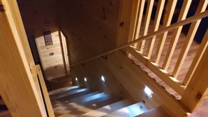 A wooden staircase with a handrail, leading to a landing with a small window. - Princesses Mountain View ,  Romantic/Honeymoon getaway   (Sevierville)