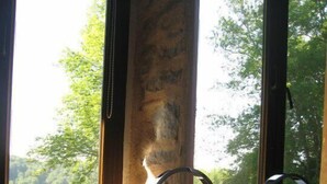 A bathroom with a white sink, a mirror, and a window with a view of trees. - Hotel Le Morimont (Oberlarg)