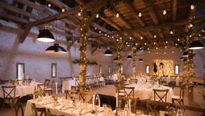 A banquet hall with tables set for a formal event, featuring wooden beams and hanging light fixtures. - Hotel Le Morimont (Oberlarg)