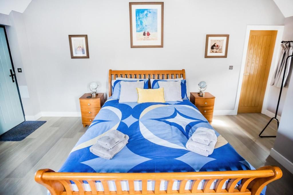 Ein Schlafzimmer mit einem hölzernen Bett, zwei Nachttischen, einem Beistelltisch und einer Tür.