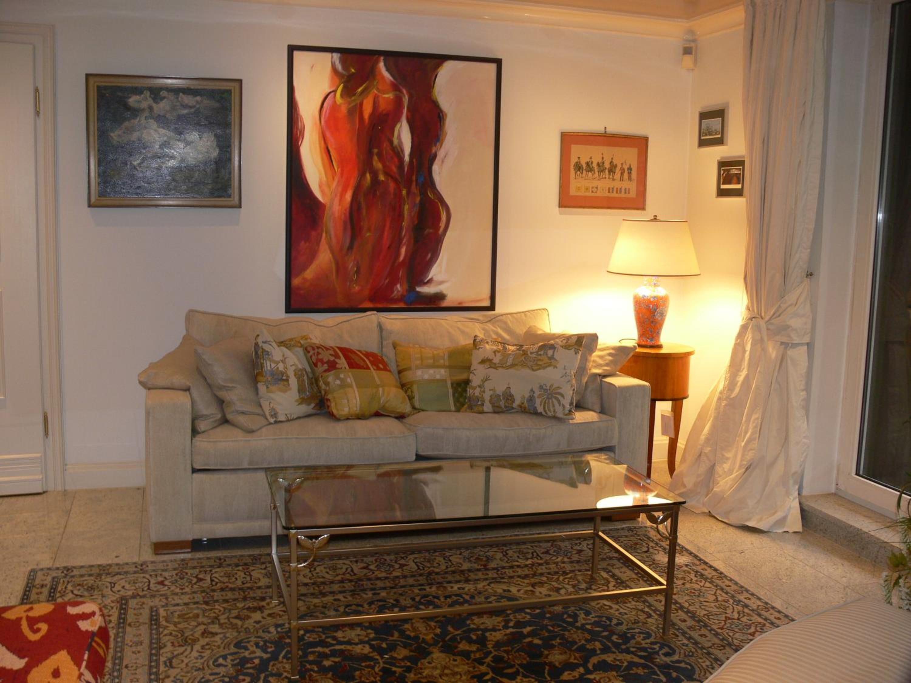 A living room with a sofa, a coffee table, a lamp, and a rug.