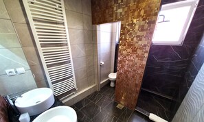 A modern bathroom with two sinks, a toilet, and a shower area. - Apartments Velickovic (Soko Banja)