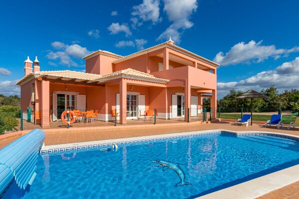 A two-story building with a swimming pool, outdoor seating, and a clear blue sky. - Villa da Horta, a beautiful extensive villa in a peaceful location (Alcantarilha)