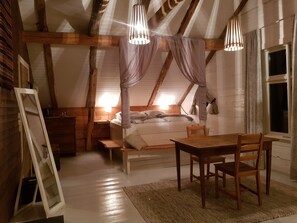 A cozy attic bedroom with a bed, wooden furniture, and a sloped ceiling. - Rødseter Inn (Sogndal)