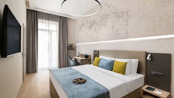 Une chambre d’hôtel moderne avec un grand lit, un bureau et une carte accrochée au mur.