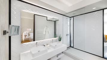 Une salle de bain moderne avec deux lavabos, un grand miroir et une douche à l’italienne.