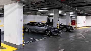 Un parking souterrain à plusieurs niveaux, où plusieurs voitures sont garées.