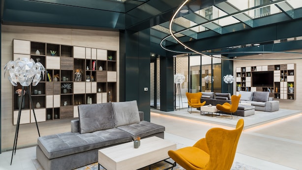 A modern interior with a grey sofa, yellow armchairs, and a wooden coffee table. - Hotel Vision (Budapest)