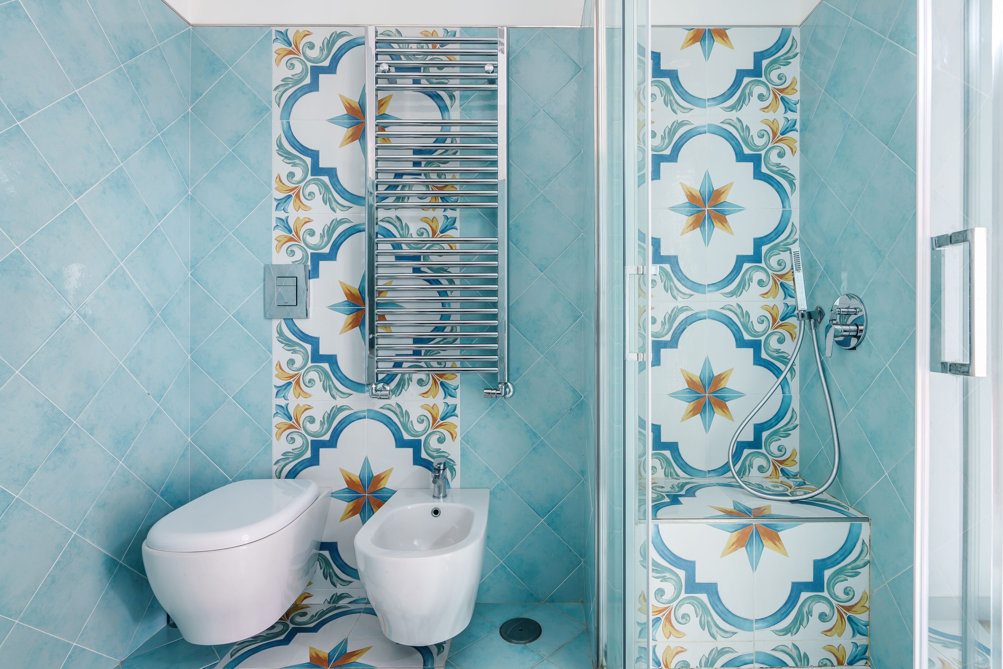 A bathroom with a shower, toilet, and bidet.