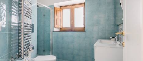Un baño con inodoro, lavabo y ducha.