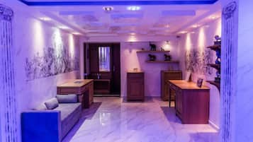 A room with a marble floor, a sofa, a small table, and a cabinet.