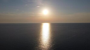 Vista del océano con el sol reflejándose en la superficie del agua.