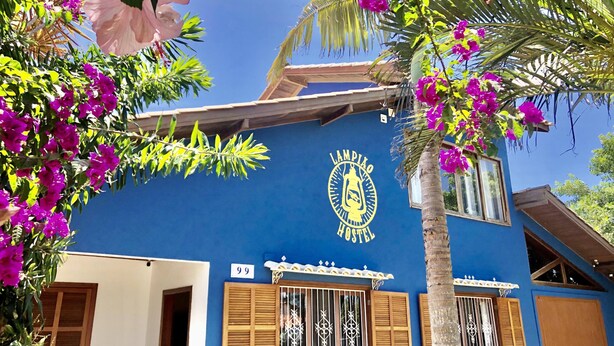 A hostel with a blue exterior, a visible room number '99', and a logo featuring a lantern. - Lampião Hostel (Florianópolis)