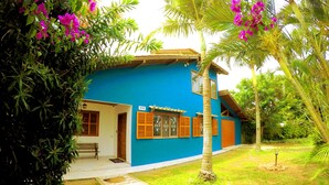 A two-story house with a blue exterior, a front porch, and a number '99' sign. - Lampião Hostel (Florianópolis)