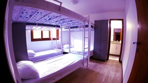 A bunk bed room with a wardrobe and a bathroom visible through an open door. - Lampião Hostel (Florianópolis)