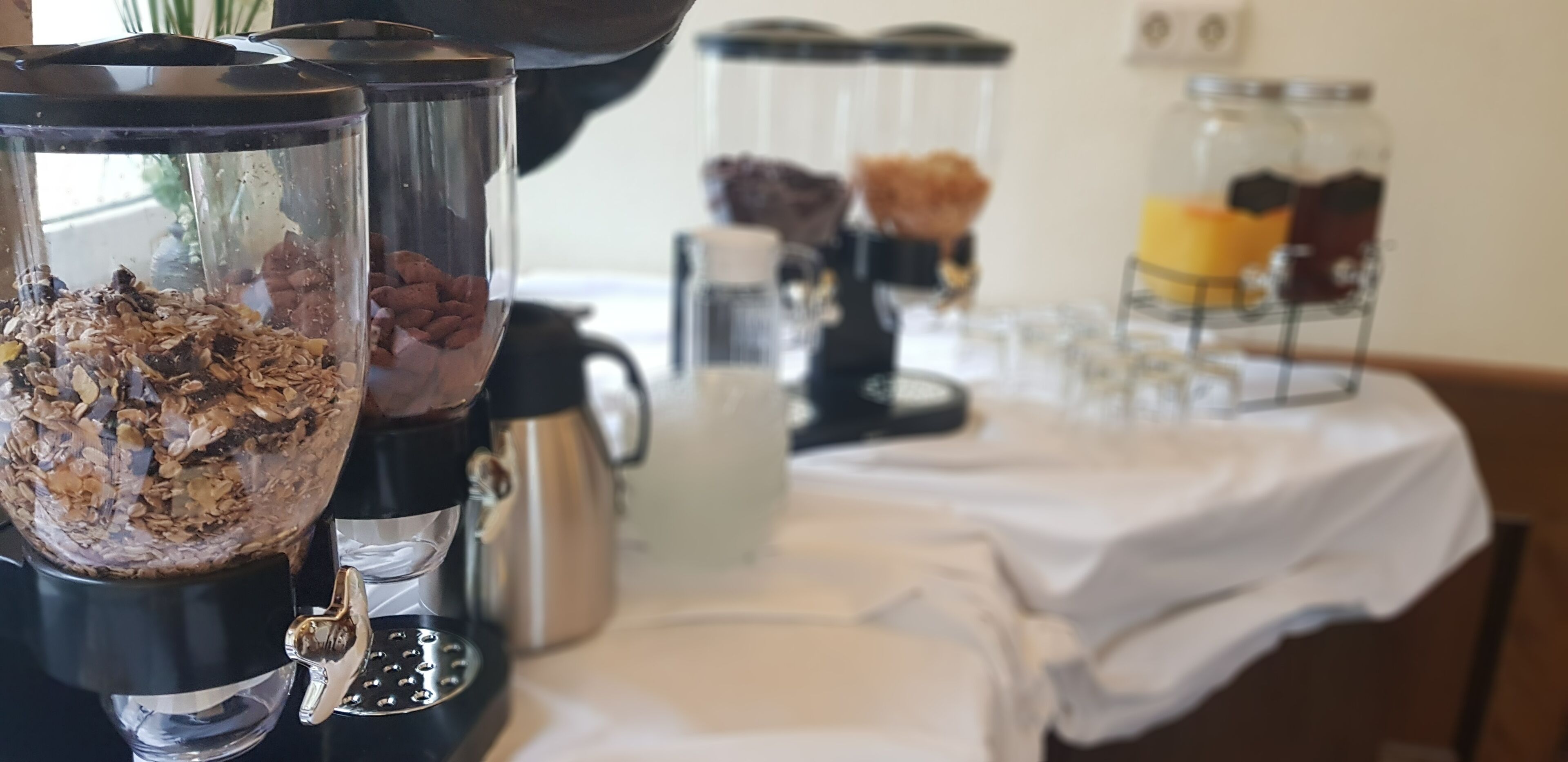A kitchen counter with a coffee maker, a blender, and jars of ingredients.