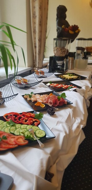 Una mesa de buffet con diversos alimentos y una máquina de café.