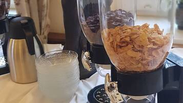 Un comptoir de cuisine avec un mixeur, une banane, une machine à café et une statue d’une femme tenant une banane.