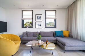 Lyxlägenhet | Vardagsrum | 60-centimeters platt-tv med kabelkanaler, LCD-tv och Netflix