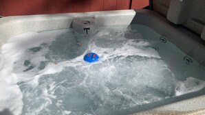 Een bubbelbad met een blauw speeltje en een T-vormig object in het water.