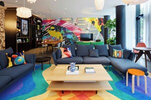 A modern living room with a sectional sofa, a coffee table, and a bookshelf.