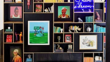 A living room with a fireplace, bookshelves, and various framed pictures and decorations.