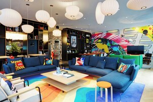 A modern lounge area with sofas, a coffee table, and a bookshelf.