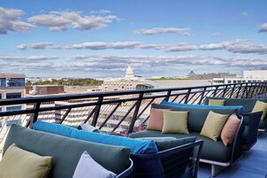 A rooftop terrace with outdoor seating and a view of the Capitol building.