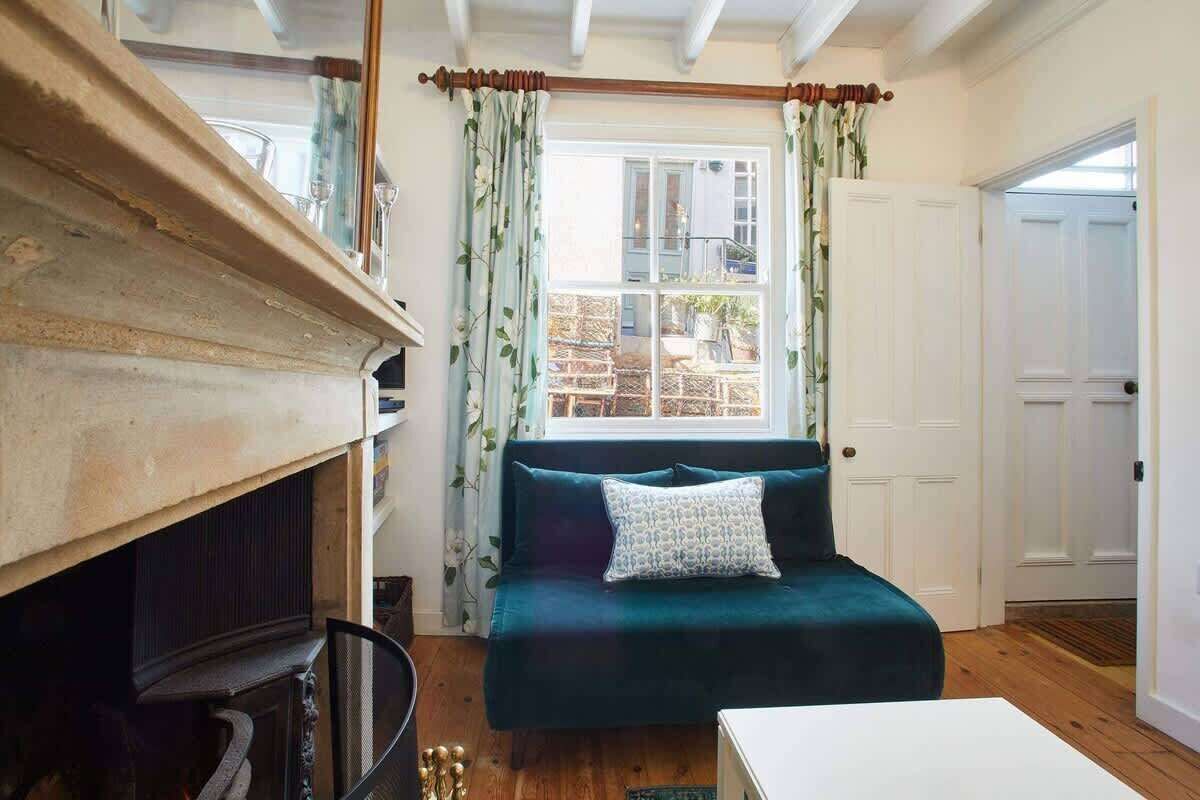 Un salon chaleureux avec une cheminée, un canapé de couleur turquoise et une porte blanche.