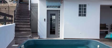 A modern building with a swimming pool, a staircase, and a door with a window.