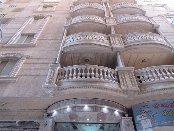 Ein Gebäude mit aufwendigen Balkonen und einem großen Fenster im Erdgeschoss.