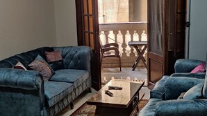 Una sala de estar con dos sofás, una mesa de centro y un tapete estampado.