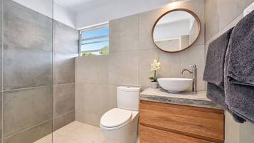 Une salle de bain moderne équipée de toilettes, d’un lavabo et d’une douche.