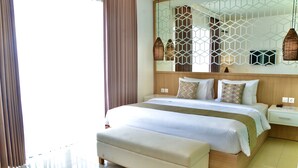 A modern hotel room with a large bed, a bench, a nightstand, and a decorative wall panel.