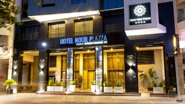 A hotel with a modern facade, large windows, and a prominent sign for Hotel Nour Plaza. - Nour Plazza Fes (Fes)
