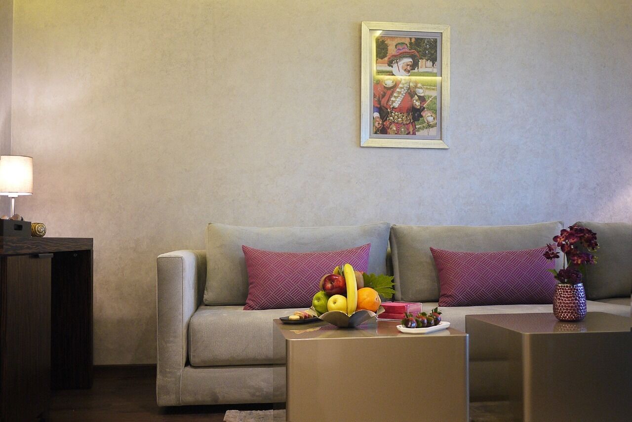 A living room with a sofa, a coffee table with fruit, and a framed picture on the wall.
