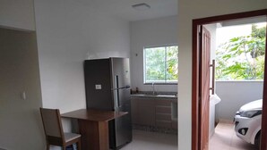 Eine Küche mit Kühlschrank, Spüle und Fenster.