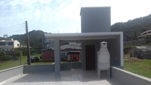 Eine Dachterrasse mit modernem architektonischen Design, mit einer großen weißen Struktur und einem gepflasterten Boden.