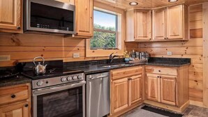 Une cuisine avec des meubles en bois, un four à micro-ondes, une cuisinière et un lave-vaisselle.
