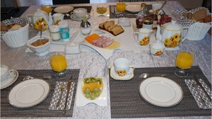 Buffet de café da manhã com diversas opções de alimentos e bebidas.