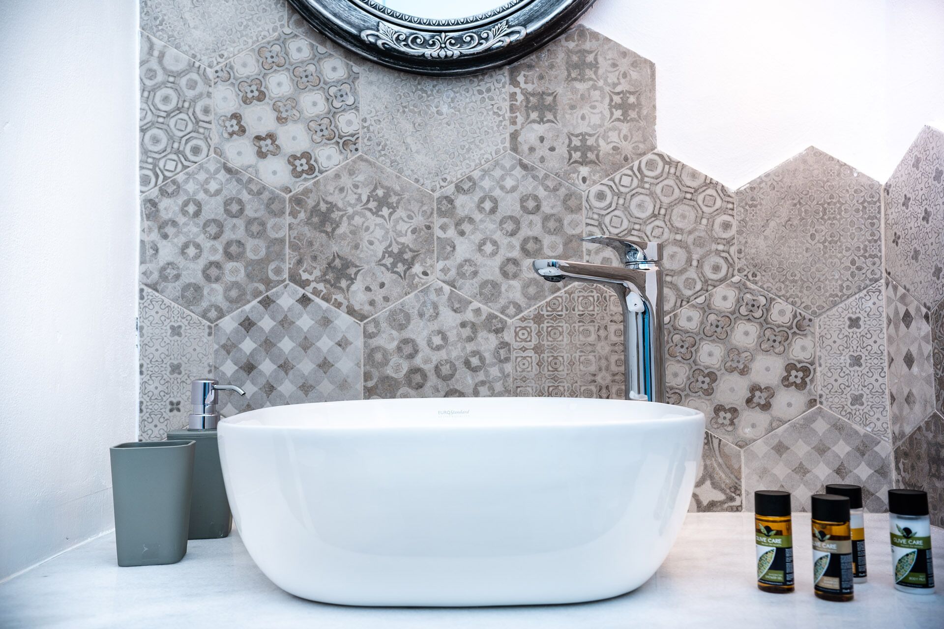 Ein Badezimmer mit einer weißen freistehenden Badewanne, einem modernen Wasserhahn und einer backsplash aus dekorativen Wandfliesen.