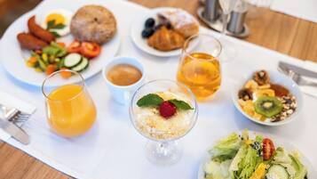 A breakfast setting with various dishes, including eggs, pastries, and a fruit salad.