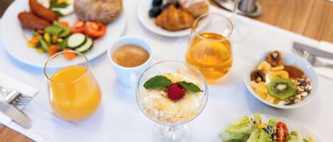 A breakfast setting with various dishes, including eggs, pastries, and a fruit salad.