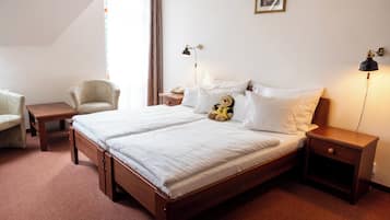 Een hotelkamer met een tweepersoonsbed, nachtkastjes, een stoel en een bureau.