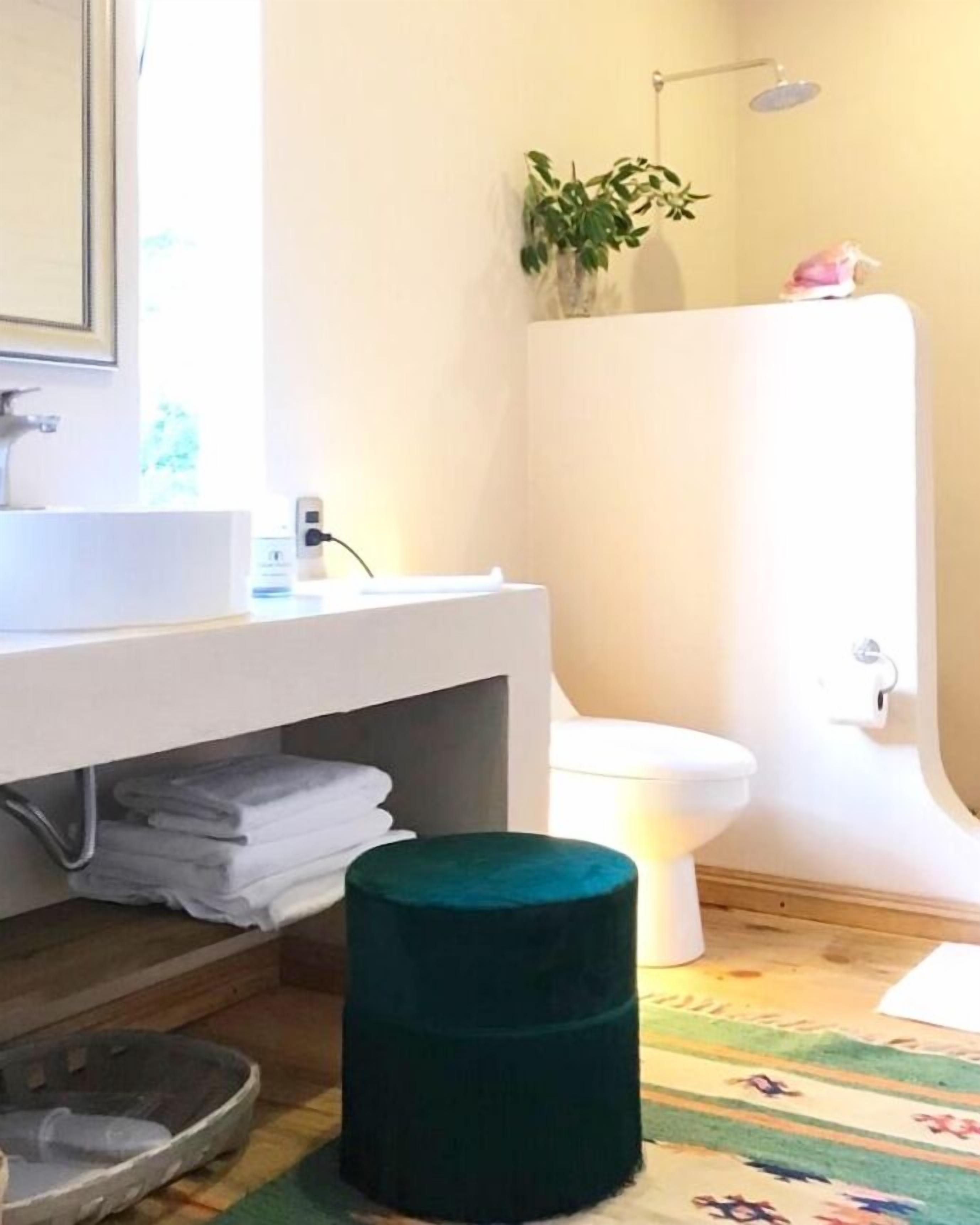 Un baño moderno con un lavabo blanco, inodoro y ducha.